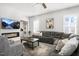 Bright living room featuring a modern fireplace with TV, stylish seating, and abundant natural light from shuttered windows at 200 Gravel Brook Ct, Cary, NC 27519
