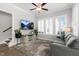 Open living room features a gray couch, modern ceiling fan, a decorative rug and large windows at 200 Gravel Brook Ct, Cary, NC 27519