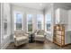 Bright sitting room with decorative chairs, white cabinets, hardwood floors, and an abundance of natural light at 200 Gravel Brook Ct, Cary, NC 27519