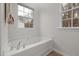 Bathroom with large soaking tub and tile flooring with two windows for natural light at 2114 Frissell Ave, Apex, NC 27502