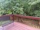 View from the deck looking out to a wooded area with a bench and playhouse in the background at 2114 Frissell Ave, Apex, NC 27502