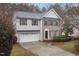 Two-story home featuring brick and siding exterior, trimmed bushes, and a two-car garage at 2114 Frissell Ave, Apex, NC 27502