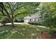 Charming two-story home with a lush, green front yard and mature trees providing ample shade at 2114 Frissell Ave, Apex, NC 27502