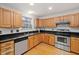 Traditional kitchen with stainless steel appliances, wood cabinets, and black countertops offers a timeless design at 2114 Frissell Ave, Apex, NC 27502