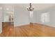Spacious living area with hardwood floors, neutrally painted walls, view of outdoor space, and chandelier at 2114 Frissell Ave, Apex, NC 27502