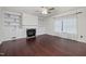 Cozy living room with fireplace, built-in shelving, wood floors, and a ceiling fan at 2114 Frissell Ave, Apex, NC 27502