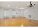 Spacious living room featuring hardwood floors, stairs, white walls, and elegant chandelier at 2114 Frissell Ave, Apex, NC 27502