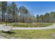 Walking path leading to a pond with a bench overlooking it in a lush setting at 2114 Frissell Ave, Apex, NC 27502