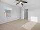 A well lit bedroom features a window, a ceiling fan, carpet floors, and neutral paint at 2117 Mckenzie Ridge Lane Ln, Apex, NC 27502