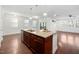 Kitchen island with stainless steel sink and adjacent dining area with hardwood floors at 2117 Mckenzie Ridge Lane Ln, Apex, NC 27502