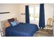 Cozy bedroom featuring a window and a comfortable bed with stylish blue bedding at 2213 Oakhurst Trl, Hillsborough, NC 27278