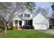 Charming two-story home featuring a covered porch, well-maintained lawn, and attached garage at 2213 Oakhurst Trl, Hillsborough, NC 27278