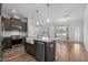 Open kitchen boasts a center island with granite countertops, stainless steel appliances, and wood floors at 236 Shingle Oak Rd, Wake Forest, NC 27587
