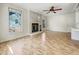 Spacious living room with a brick fireplace, hardwood floors, a ceiling fan, and large windows at 308 Trimble Ave, Cary, NC 27511