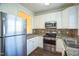 The kitchen offers stainless steel appliances, white cabinets, and granite countertops at 4120 Standing Rock Way, Raleigh, NC 27604