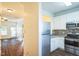 Modern kitchen with stainless steel appliances, white cabinetry, a tile backsplash, and access to the living room at 4120 Standing Rock Way, Raleigh, NC 27604