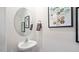 Contemporary powder room with a pedestal sink, oval mirror, and modern wall art at 426 Belgian Red Way, Wake Forest, NC 27587