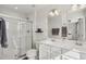 Modern bathroom with double vanity, framed mirror and a walk-in shower with glass door at 4918 Neuse Commons Ln, Raleigh, NC 27616