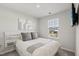 Simple bedroom with mounted television, and a window letting in lots of natural light at 4918 Neuse Commons Ln, Raleigh, NC 27616