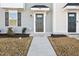 Close-up of a stylish gray front door with dark fixtures, house number, and landscaped entrance for a warm welcome at 4918 Neuse Commons Ln, Raleigh, NC 27616