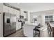 Bright eat-in kitchen features stainless steel appliances, white cabinetry, and large center island with seating at 4918 Neuse Commons Ln, Raleigh, NC 27616