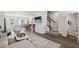 Open-concept living room with hardwood floors, staircase, and lots of light for a modern and inviting space at 4918 Neuse Commons Ln, Raleigh, NC 27616