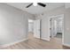 Bright bedroom with light wood floors, ceiling fan, and doorways to closet and bathroom at 615 W Peace St # 406, Raleigh, NC 27605