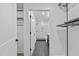 View down hallway to modern bathroom with glass enclosed shower and dark cabinets at 615 W Peace St # 406, Raleigh, NC 27605