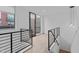 Hallway with black metal railings leading to a sliding glass door and small balcony at 615 W Peace St # 406, Raleigh, NC 27605