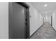 Hallway featuring modern gray door, carpeted floors, and white walls at 615 W Peace St # 406, Raleigh, NC 27605