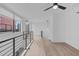 Bright living room featuring light wood floors, modern railing, and a ceiling fan at 615 W Peace St # 406, Raleigh, NC 27605
