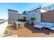 A rooftop deck with wood floor has an outdoor dining set, sectional sofa and some plants at 615 W Peace St # 406, Raleigh, NC 27605