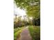Picturesque community walking path with mature trees, green grass, and park benches for a relaxing stroll at 615 W Peace St # 406, Raleigh, NC 27605
