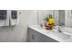 Bright bathroom features a dual sink vanity with gray cabinets, quartz countertops, and decorative accents at 6448 Alfalfa Ln, Wake Forest, NC 27587