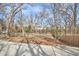 Image shows a backyard with an open space enclosed by fencing and bordered by trees at 723 Holloway St, Durham, NC 27701