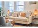 Comfortable living room featuring a neutral sofa, decorative pillows, and stylish accents under bright natural light at 723 Holloway St, Durham, NC 27701