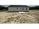Back view of a single-story home with a concrete patio and a lush green lawn at 73 Grace Pond Ave, Benson, NC 27504
