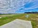 A concrete slab sits in an unfinished backyard with green grass and distant trees and skies at 73 Grace Pond Ave, Benson, NC 27504