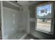 Unfinished bathroom features a window and a shower and tub combination at 73 Grace Pond Ave, Benson, NC 27504