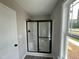 Modern bathroom features a walk-in shower with black trim, window and neutral wall color at 73 Grace Pond Ave, Benson, NC 27504