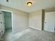 Carpeted bedroom with closet and white door at 73 Grace Pond Ave, Benson, NC 27504