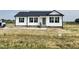 New construction features a white exterior, black shutters, and a well-manicured lawn at 73 Grace Pond Ave, Benson, NC 27504