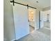 Main bathroom with sliding barn door, double sink vanity, and neutral paint at 73 Grace Pond Ave, Benson, NC 27504