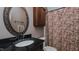 Bathroom with granite sink and shower with patterned curtain at 802 N Fifth St, Mebane, NC 27302