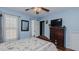 Bedroom with blue walls and a ceiling fan, featuring a classic wood dresser with a TV on top at 802 N Fifth St, Mebane, NC 27302