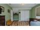 Bedroom featuring wood floors, a ceiling light, and a closet with bi-fold doors at 802 N Fifth St, Mebane, NC 27302
