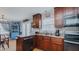 Well-lit kitchen with wood cabinets, stainless steel appliances, and a view into the dining area at 802 N Fifth St, Mebane, NC 27302