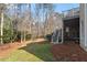 A view of the backyard of a home featuring a porch, wooden stairs, grass, and mature trees at 803 Landuff Ct, Cary, NC 27519