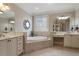 Bright bathroom featuring dual vanities, soaking tub, and decorative accents at 803 Landuff Ct, Cary, NC 27519