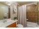 Bathroom featuring a single vanity, framed mirror, and a tub with shower, creating a functional space at 803 Landuff Ct, Cary, NC 27519